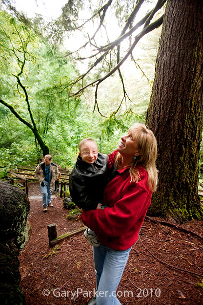 Shelly holds 18 year old Nick during a walk through the redwoods as his Dad, Lawrence, follows. 